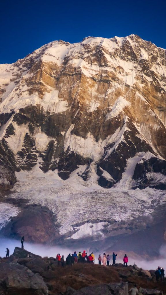 Hikers crossing high mountain terrain protected by activity top-up insurance for trekking.