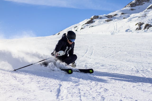 Skier descending a mountain piste, representing activities commonly covered by skiing holiday insurance.